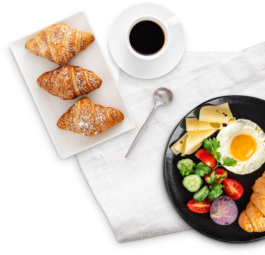 Frühstück mit Croissants, Ei, Käse, Gemüse und Kaffee